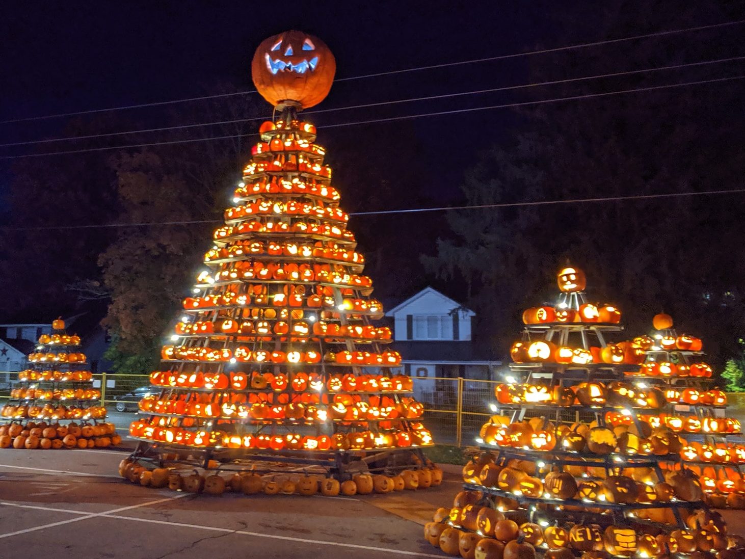 Pumpkins carved by Waterford elementary students are lit up on on tiered stands. 